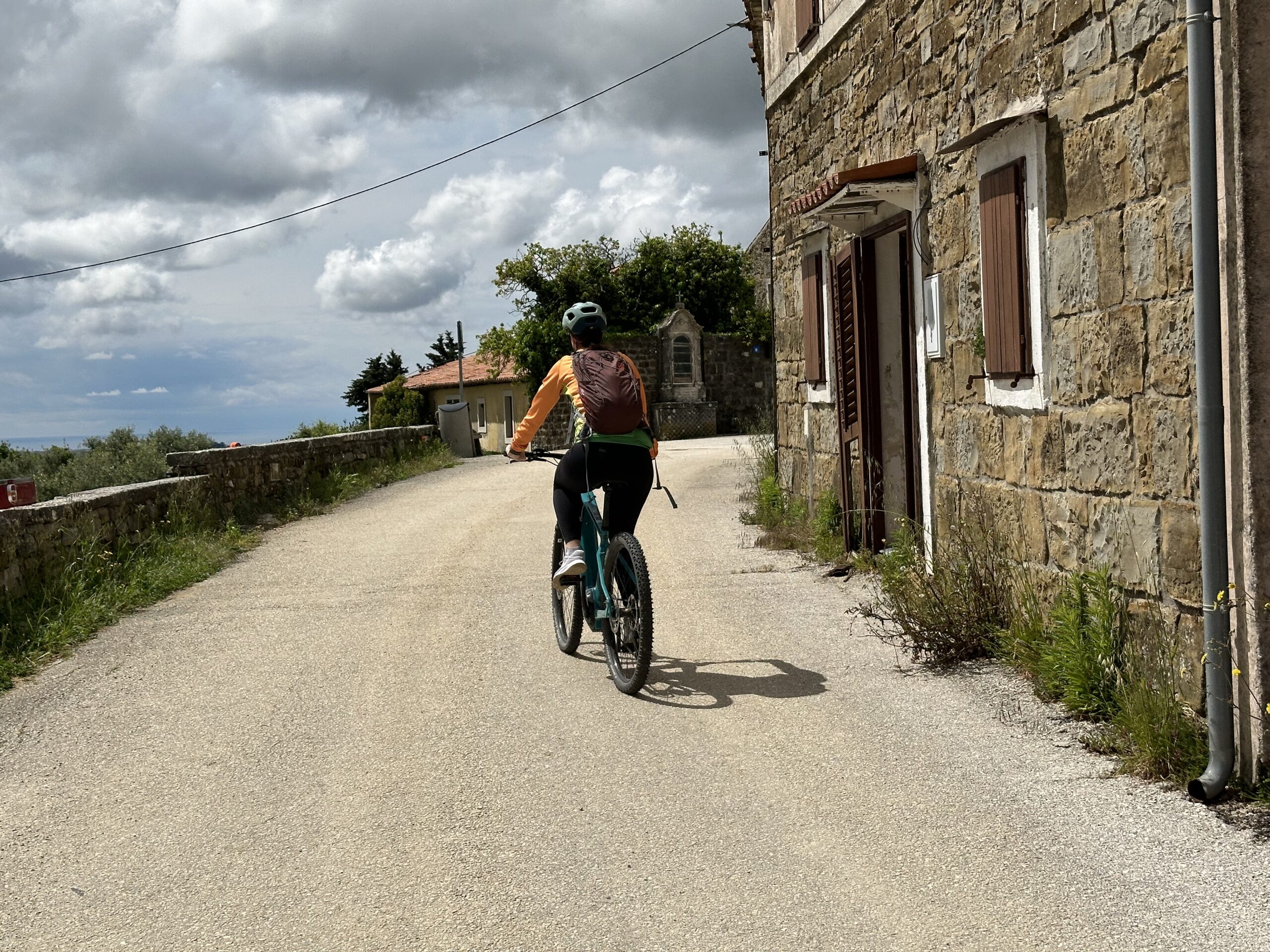Cyclist riding through a stone village in Istria